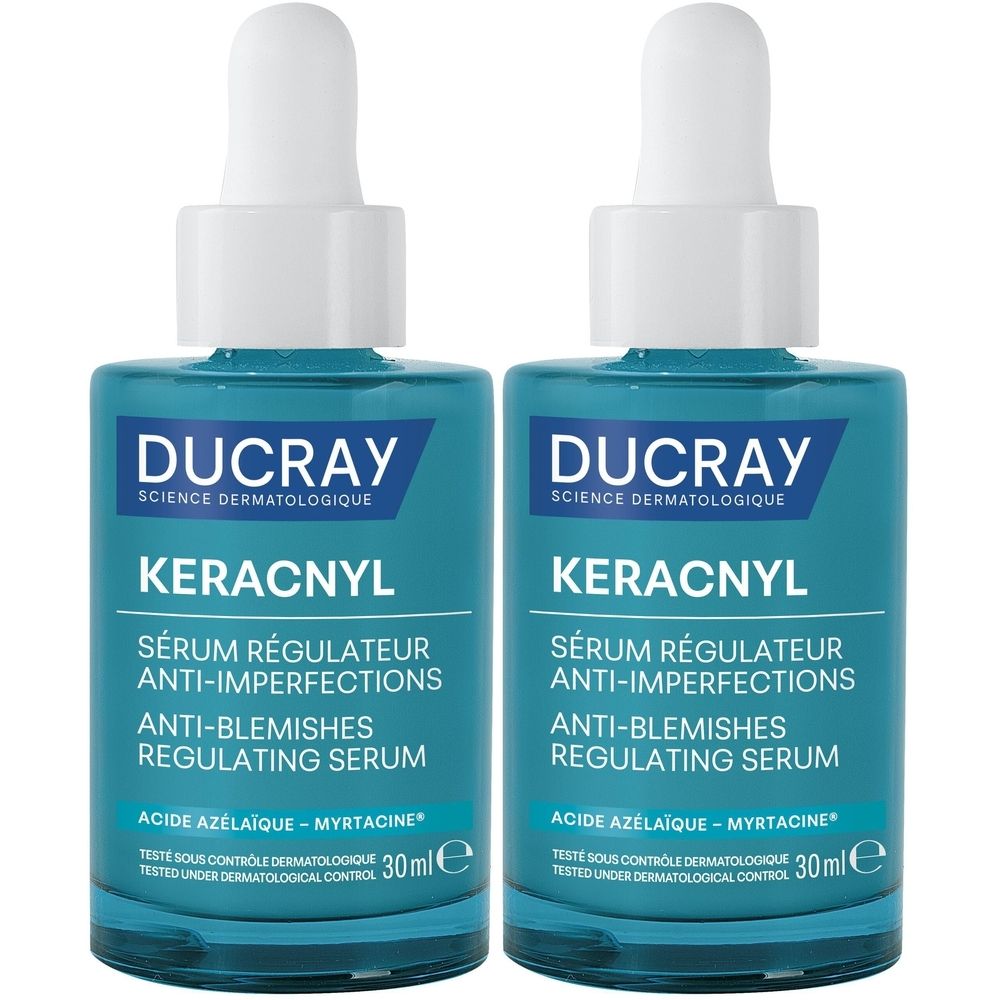 Deux flacons de sérum KERACNYL. Flacons en verre bleu avec bouchon blanc et pipette. Inscription : DUCRAY, KERACNYL, Sérum régulateur anti-imperfections.