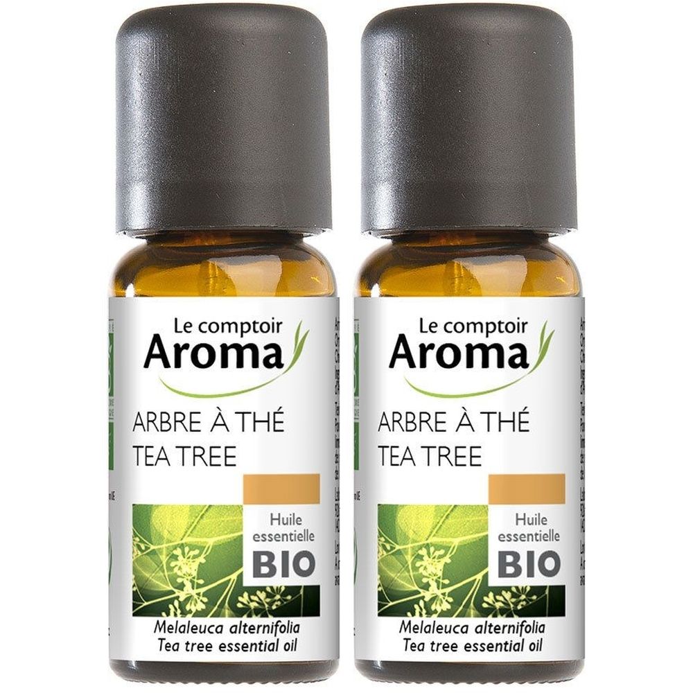 Deux flacons en verre brun avec bouchons noirs. Étiquettes : "Le comptoir Aroma", "ARBRE À THÉ TEA TREE" et "BIO". Huile essentielle.