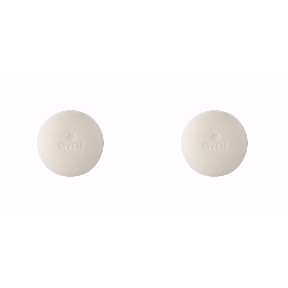 Deux pains de savon ronds, crème. Le mot "avril" et un symbole sont gravés sur chacun.