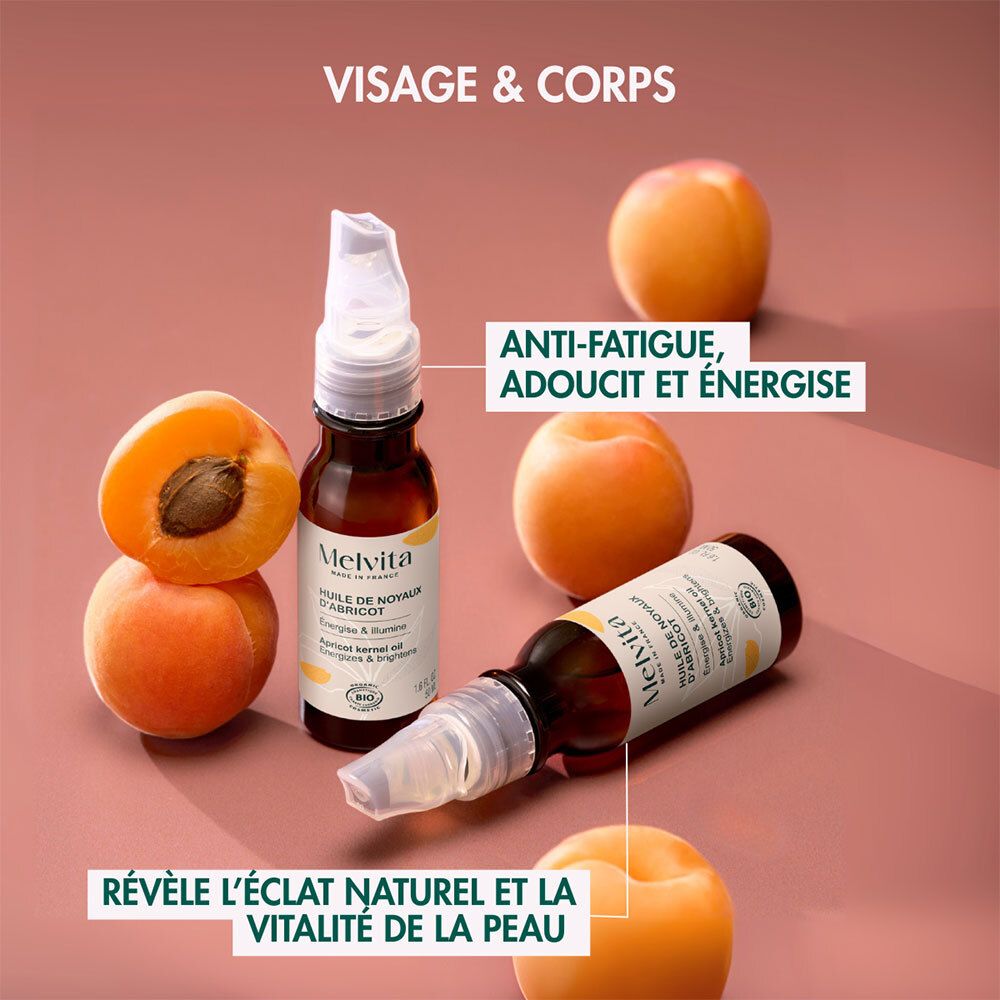 Flacon d'huile de noyau d'abricot Melvita et abricots. Texte : Visage & Corps. Textes : Anti-Fatigue, Adoucit et Énergise.