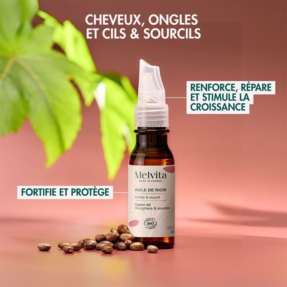 Flacon d'huile de ricin bio Melvita avec applicateur, entouré de fèves de ricin et de feuilles.