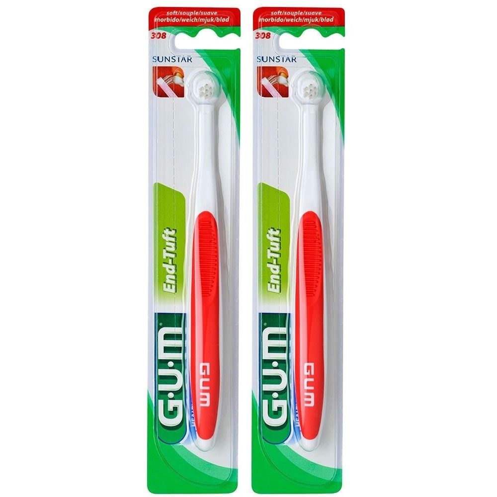 Deux brosses à dents dans leur emballage. Soies blanches, manche rouge, emballage vert et blanc. Marque G.U.M, modèle End-Tuft.