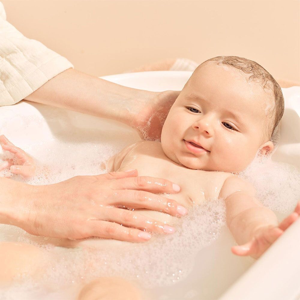 Deux flacons de gel lavant pour bébé. Un grand et un petit, côte à côte.