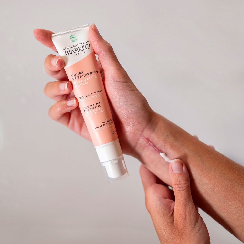 Gros plan d'une main avec une ligne de crème blanche sur la peau.