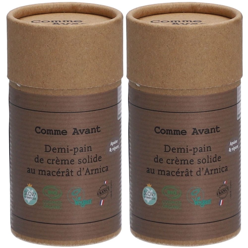 Deux contenants cylindriques en carton brun. Inscription: Comme Avant, Demi-pain de crème solide au macérât d'Arnica. Avec labels Vegan et Slow Cosmétique.