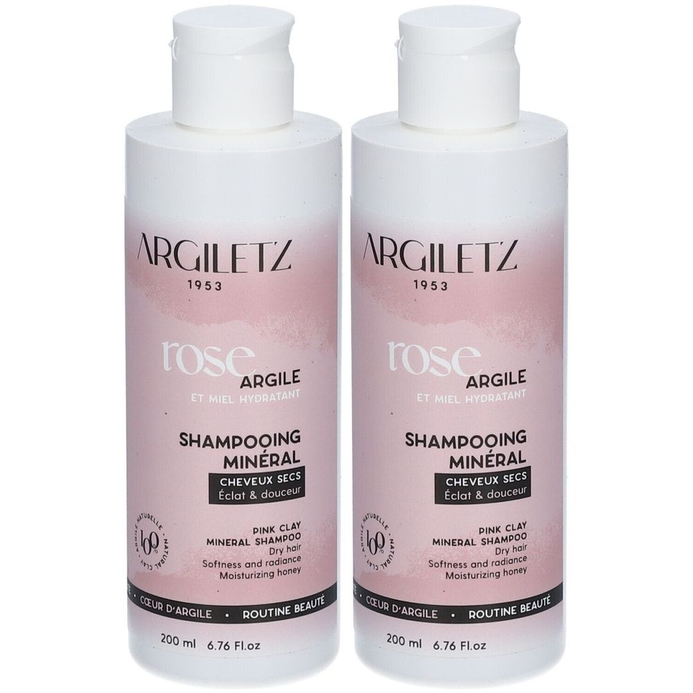 Deux flacons de shampooing. Étiquette blanc-rose avec nom et texte du produit. Contient des minéraux et du miel. Pour cheveux secs.