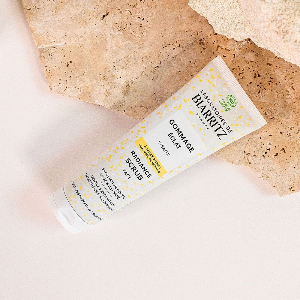 Tube sur une surface. Inscription: GOMMAGE ÉCLAT, RADIANCE SCRUB, FACE. Logo: LABORATOIRES DE BIARRITZ.