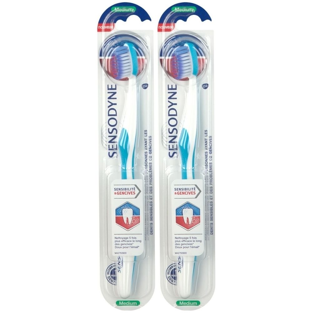 Deux brosses à dents Sensodyne Medium, emballées. Têtes bleues et rouges, manches blancs. Emballage avec informations produit.