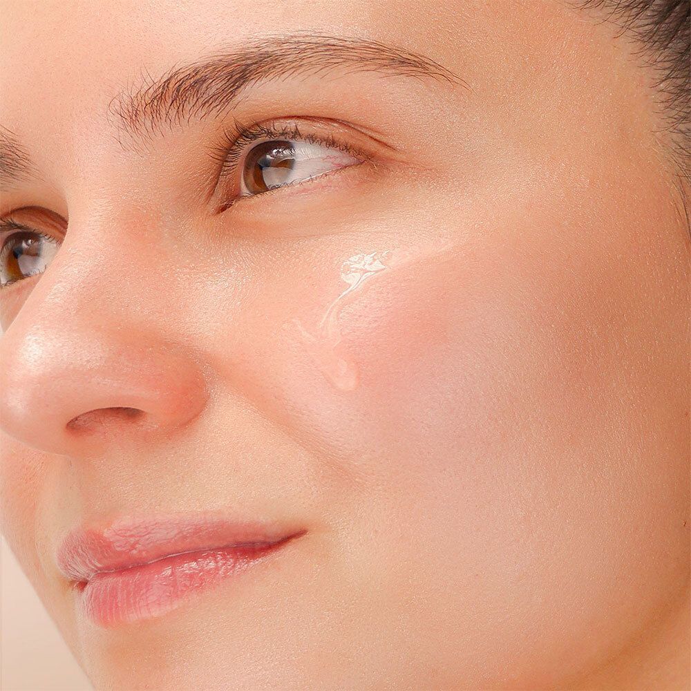 Gros plan d'un visage avec une goutte de liquide sur la peau.