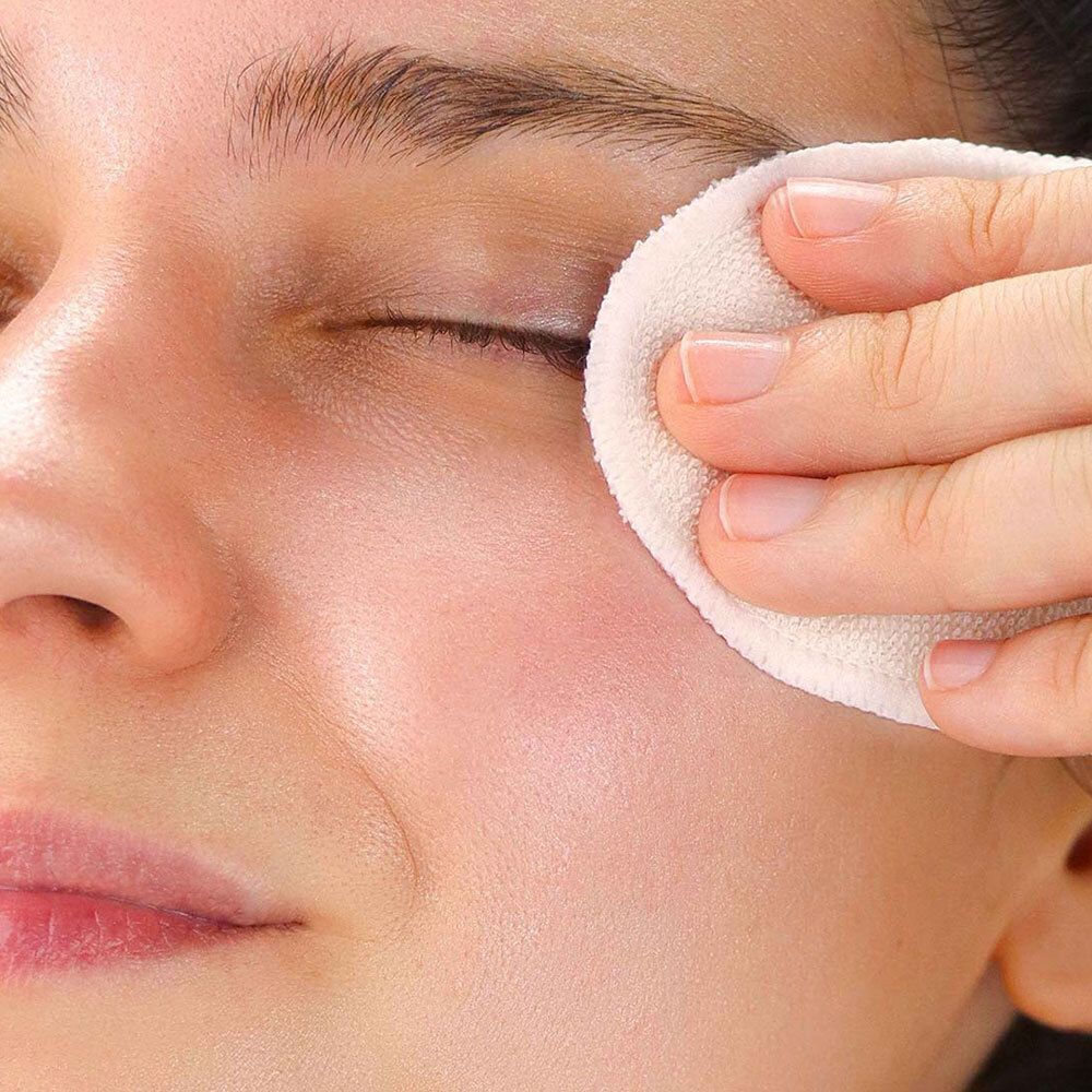 Une personne nettoie l'œil avec un tampon de coton rond. Gros plan sur le visage.