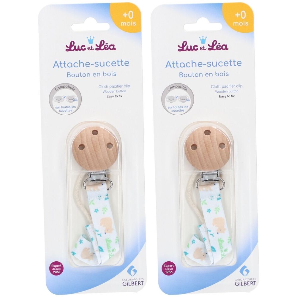 Deux attaches-sucettes Luc et Léa en emballage. Bouton en bois, attache en tissu à motifs. Marque Gilbert. Âge +0 mois.
