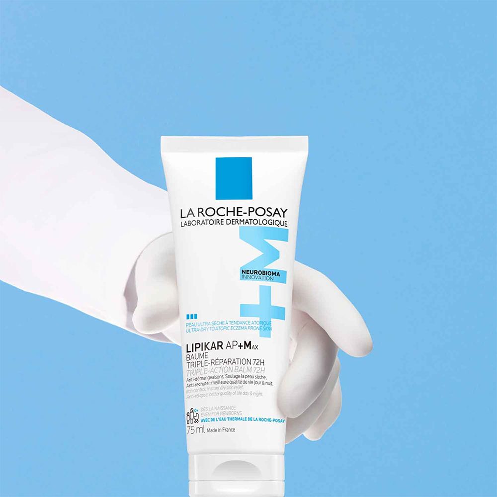 Tube blanc tenu par une main gantée. Logo bleu et inscription: La Roche-Posay.