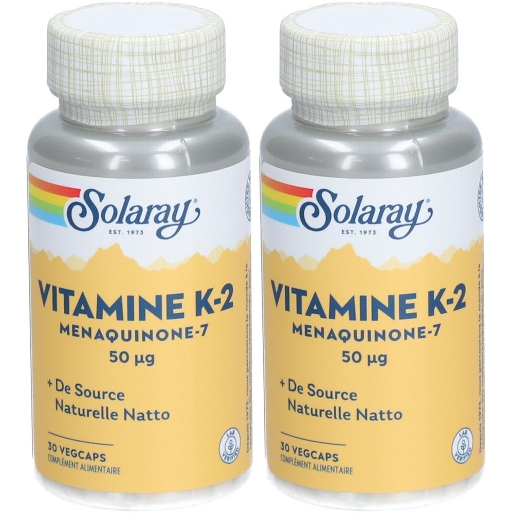 Deux flacons avec bouchons blancs et corps argentés. Inscription: Solaray, VITAMINE K-2, Menaquinone-7, 50 µg. Fond jaune.