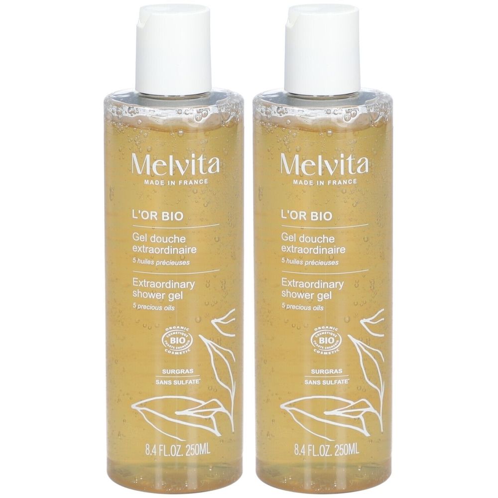 Deux flacons de gel douche. Gel transparent doré. Inscriptions: Melvita, L'Or Bio, Extraordinary shower gel. Certification Bio.
