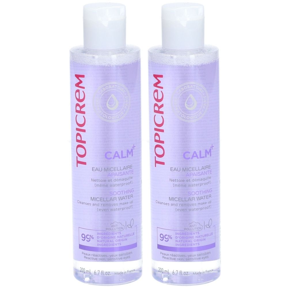 Deux flacons de Topicrem CALM+ Eau Micellaire. Étiquettes violettes, bouchons blancs. Texte: CALM+, Eau Micellaire Apaisante, 99% ingrédients naturels.