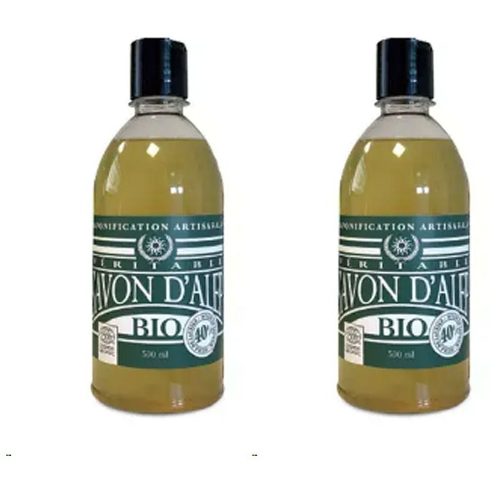 Deux flacons de Savon D'Alep Bio. Liquide clair jaunâtre dans des bouteilles transparentes avec bouchon noir. Étiquette avec texte.