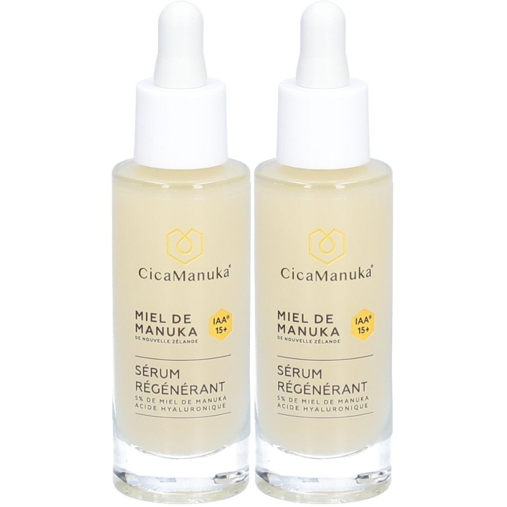 Deux flacons de CicaManuka Sérum régénérant. Flacons en verre transparent avec bouchon blanc et pipette. Liquide jaunâtre. Inscription : Miel de Manuka.