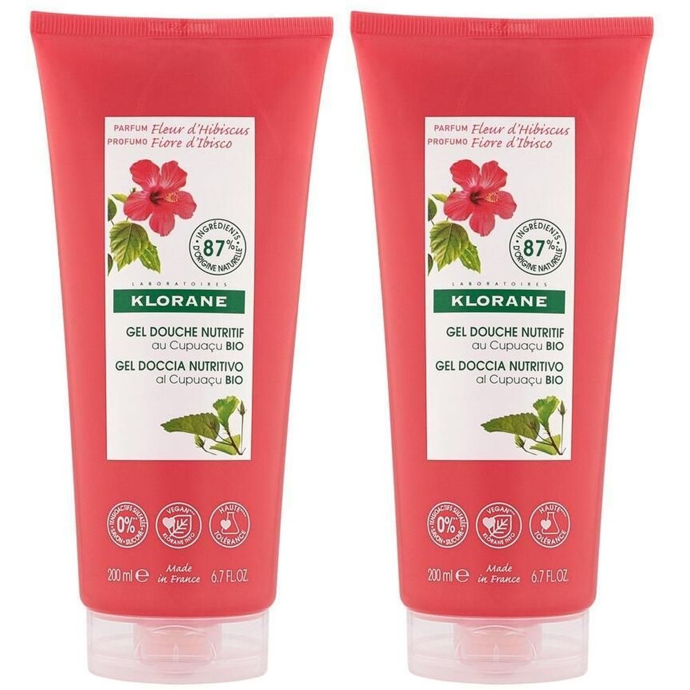 Deux tubes de gel douche KLORANE rouge. Impression avec fleur d'hibiscus et texte. Contient 87% d'ingrédients d'origine naturelle.