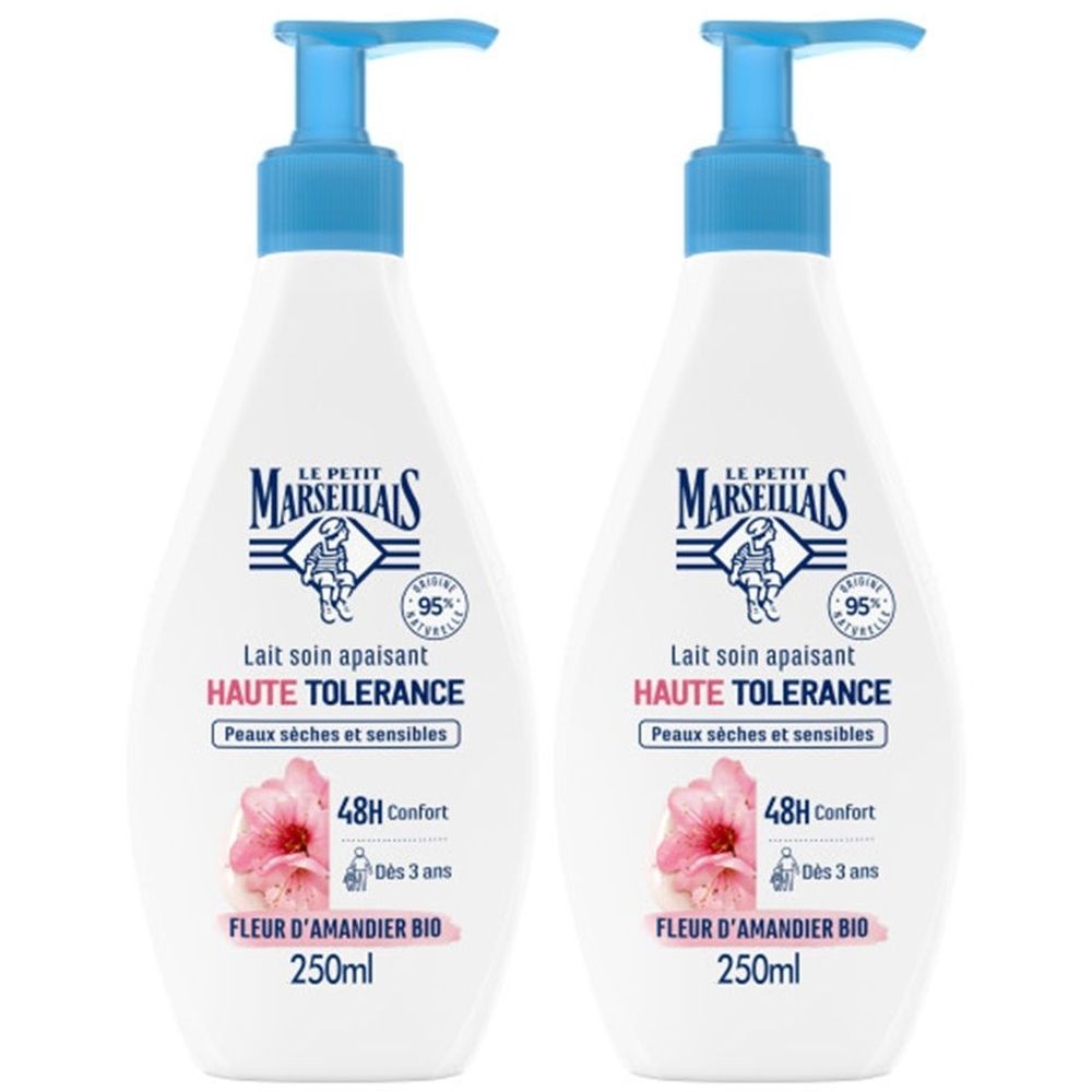 Deux flacons de Le Petit Marseillais Lait Soin Apaisant. Flacons blancs avec pompe bleue. Texte: Haute Tolérance, Fleur d'Amandier Bio.