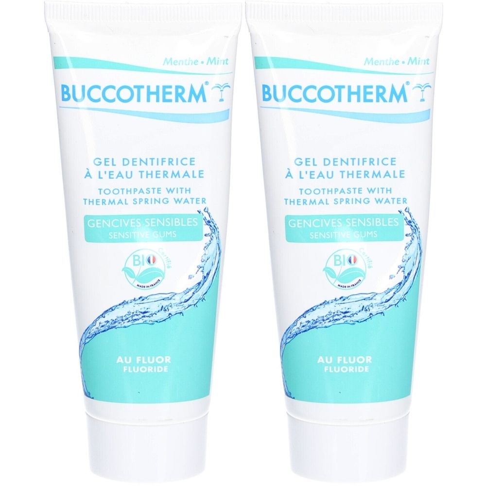 Deux tubes de gel dentifrice. Inscription: Buccotherm, Gel Dentifrice à l'eau thermale, Gencives sensibles, Bio, Au Fluor. Design turquoise et blanc.