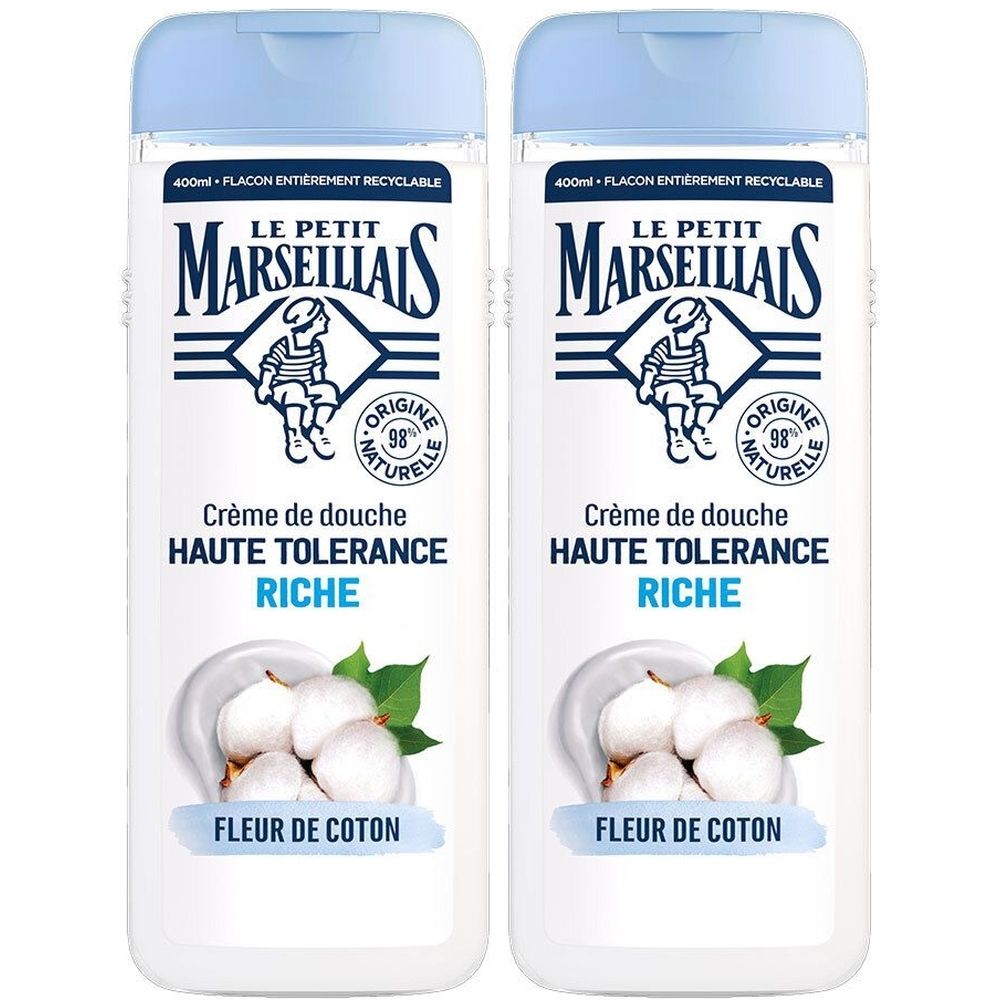 Deux flacons de crème de douche. Inscription : Le Petit Marseillais, Crème de douche Haute Tolérance Riche Fleur de Coton. Bouchon bleu, flacon blanc.