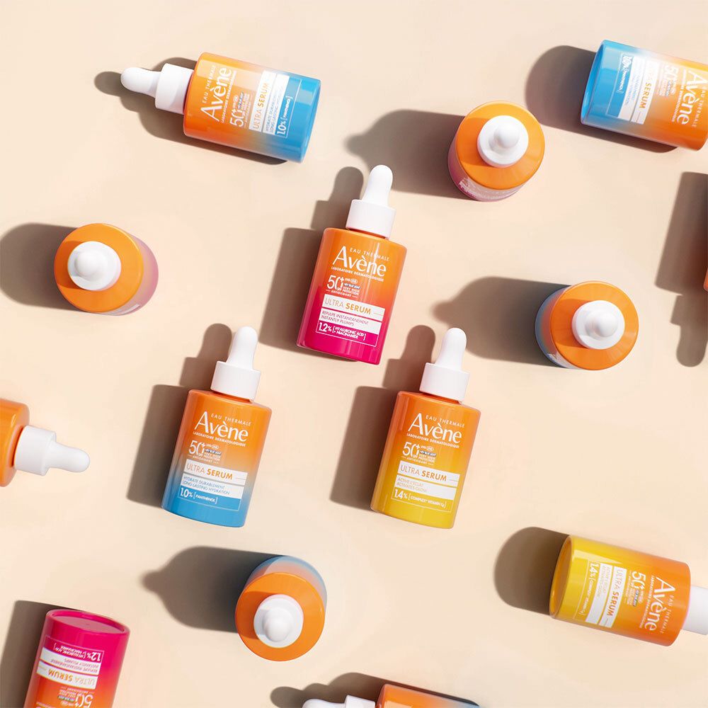 Plusieurs flacons orange avec compte-gouttes blancs. Inscriptions : Eau Thermale Avène, SPF 50+, Ultra Serum.