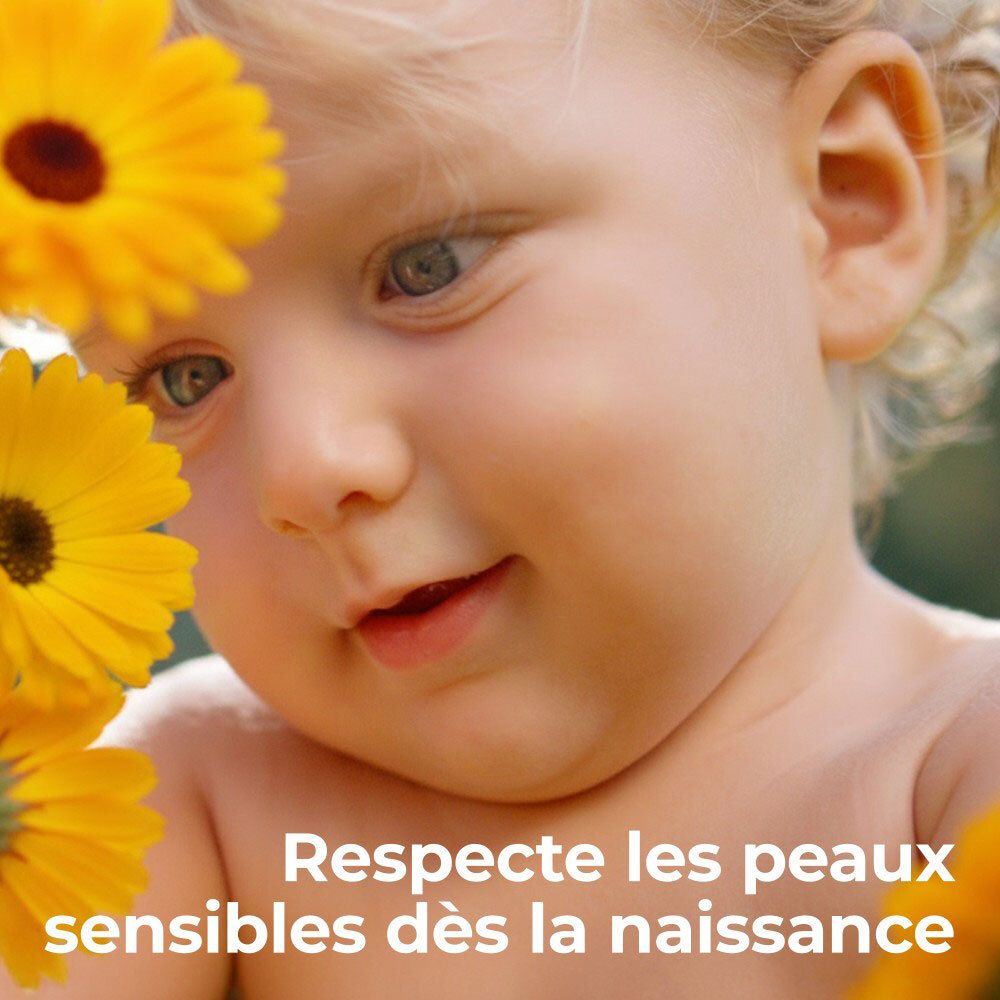 Gros plan d'un bébé avec des fleurs jaunes. Texte : Respecte les peaux sensibles dès la naissance.
