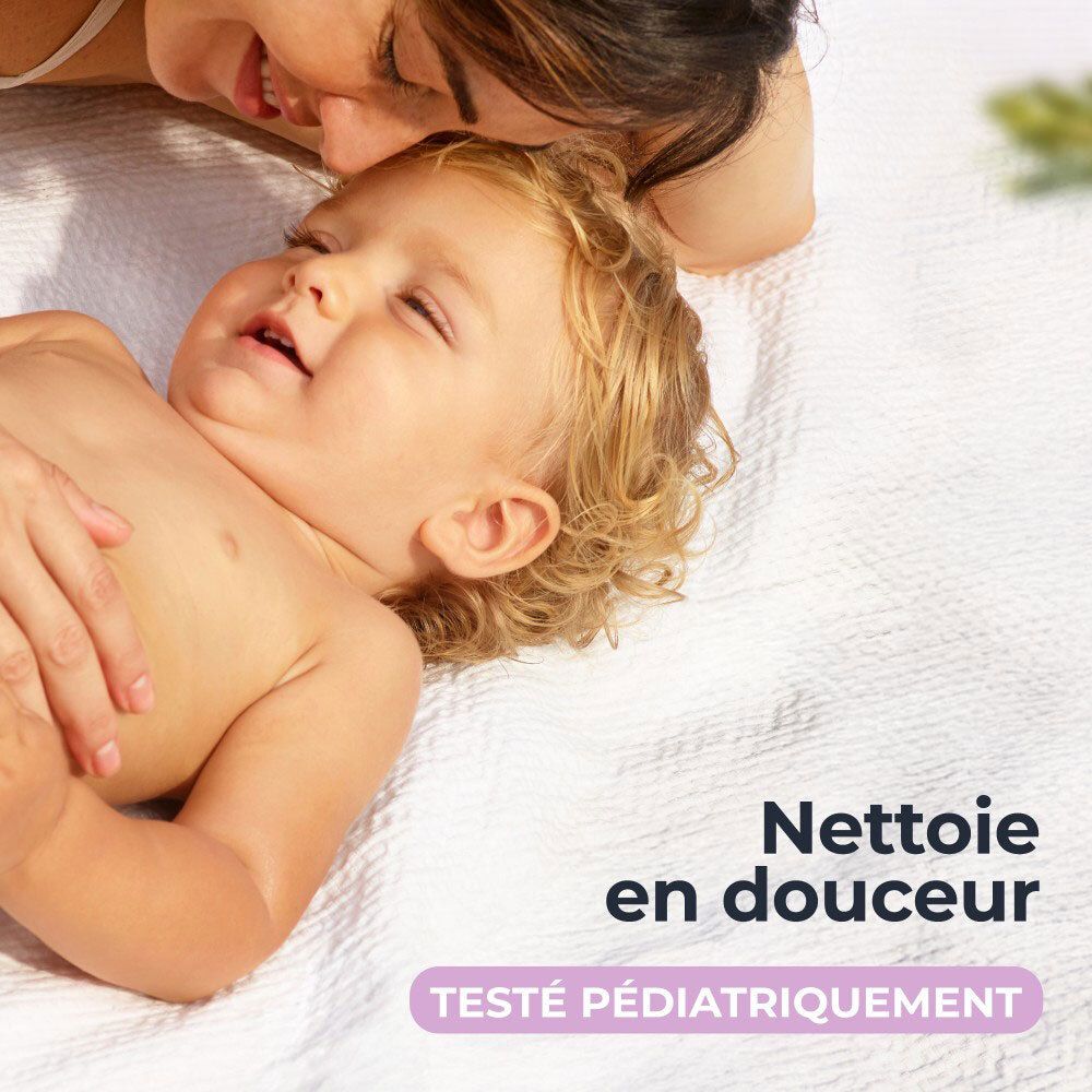Mère et bébé sur une serviette. Texte: Nettoie en douceur, Testé pédiatriquement.
