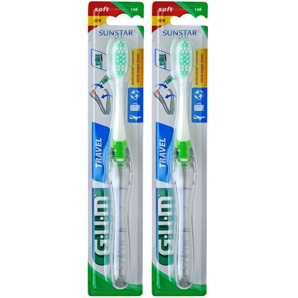 Deux brosses à dents GUM® Travel™ emballées. Manches blancs avec accent vert, étui transparent. Marque SUNSTAR.