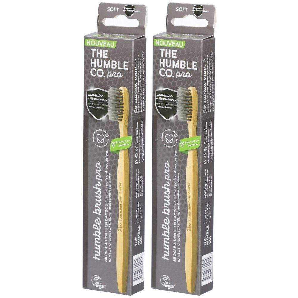 Deux brosses à dents dans leur emballage. Soies noires, manche en bambou. Inscription: Humble Brush Pro. Emballage avec inscription: The Humble Co. pro.