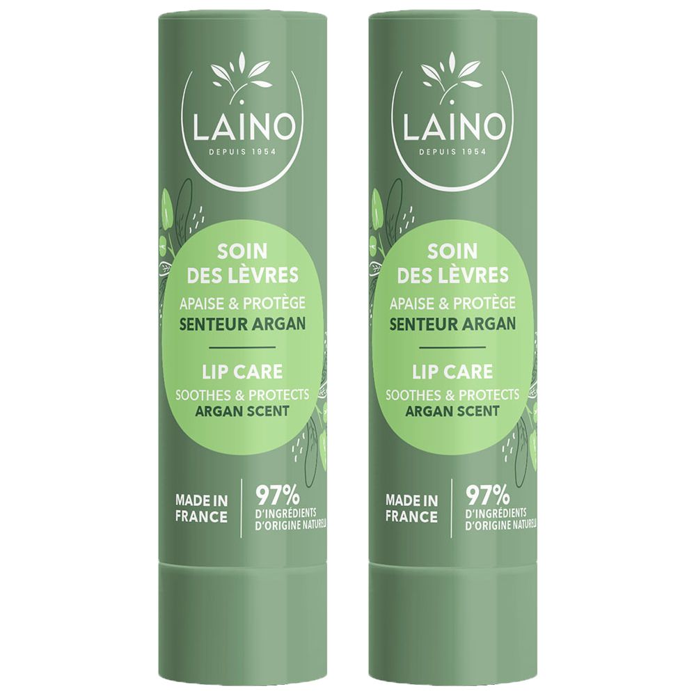 Deux baumes à lèvres verts parfum argan. "SOIN DES LÈVRES" et "LIP CARE" sont inscrits sur les bâtons.