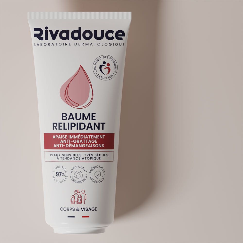 Tube blanc Rivadouce. Logo et nom du produit. Symbole goutte rose. Texte: Baume Relipidant, anti-démangeaisons, peaux sensibles, très sèches.