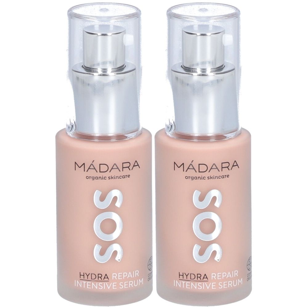 Deux flacons de sérum intensif Mádara SOS Hydra Repair. Flacons roses avec pompes argentées et bouchons transparents. Texte : Mádara, SOS.