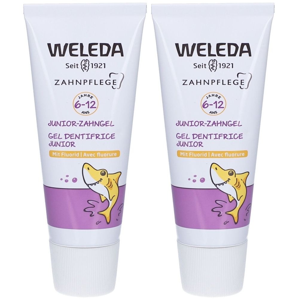 Deux tubes de gel dentifrice WELEDA Junior. Blanc, avec éléments violets et jaunes. Inscription : 6-12 ans, Avec fluorure. Illustration : requin.