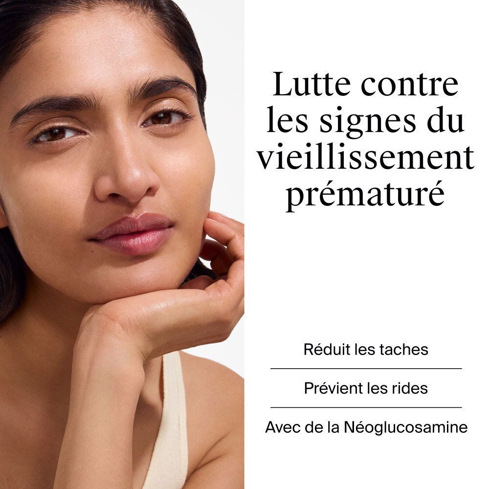 Femme touchant son visage. Texte: Lutte contre les signes du vieillissement prématuré. Réduit les taches.