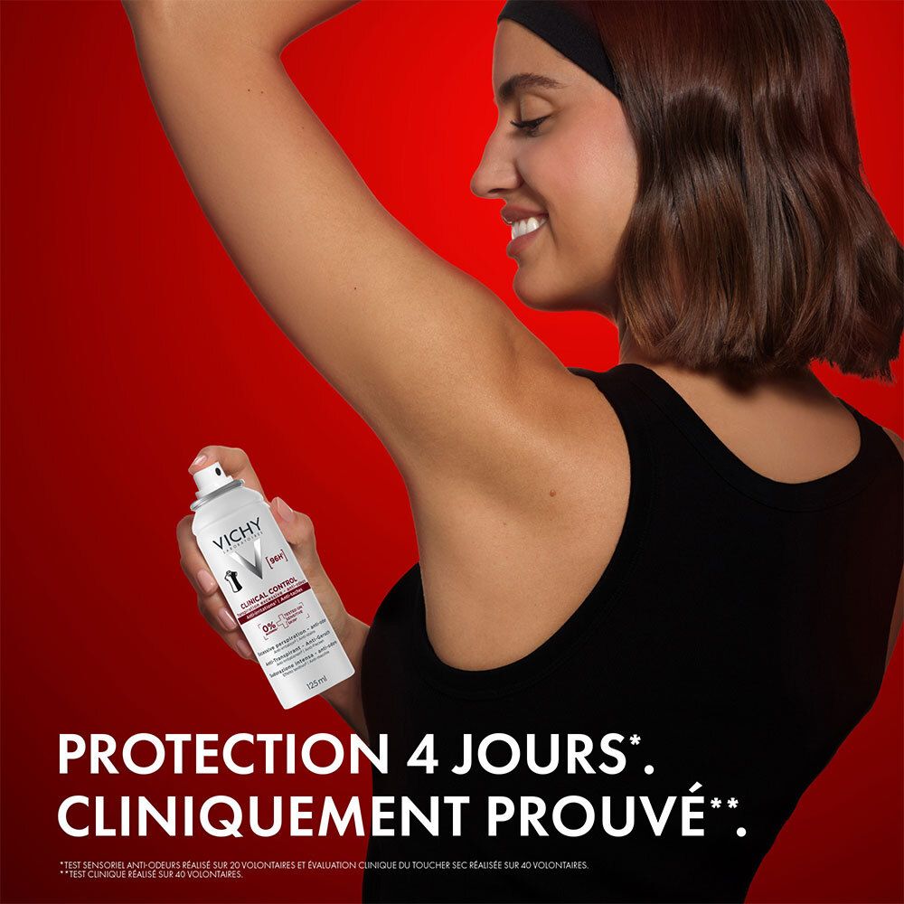 Femme tenant un spray anti-transpirant Vichy Clinical Control, fond rouge.