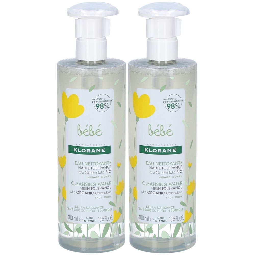 Deux flacons de KLORANE Bébé. Pompes blanches, flacons transparents avec fleurs jaunes. Texte: Eau Nettoyante, Calendula, High Tolerance.