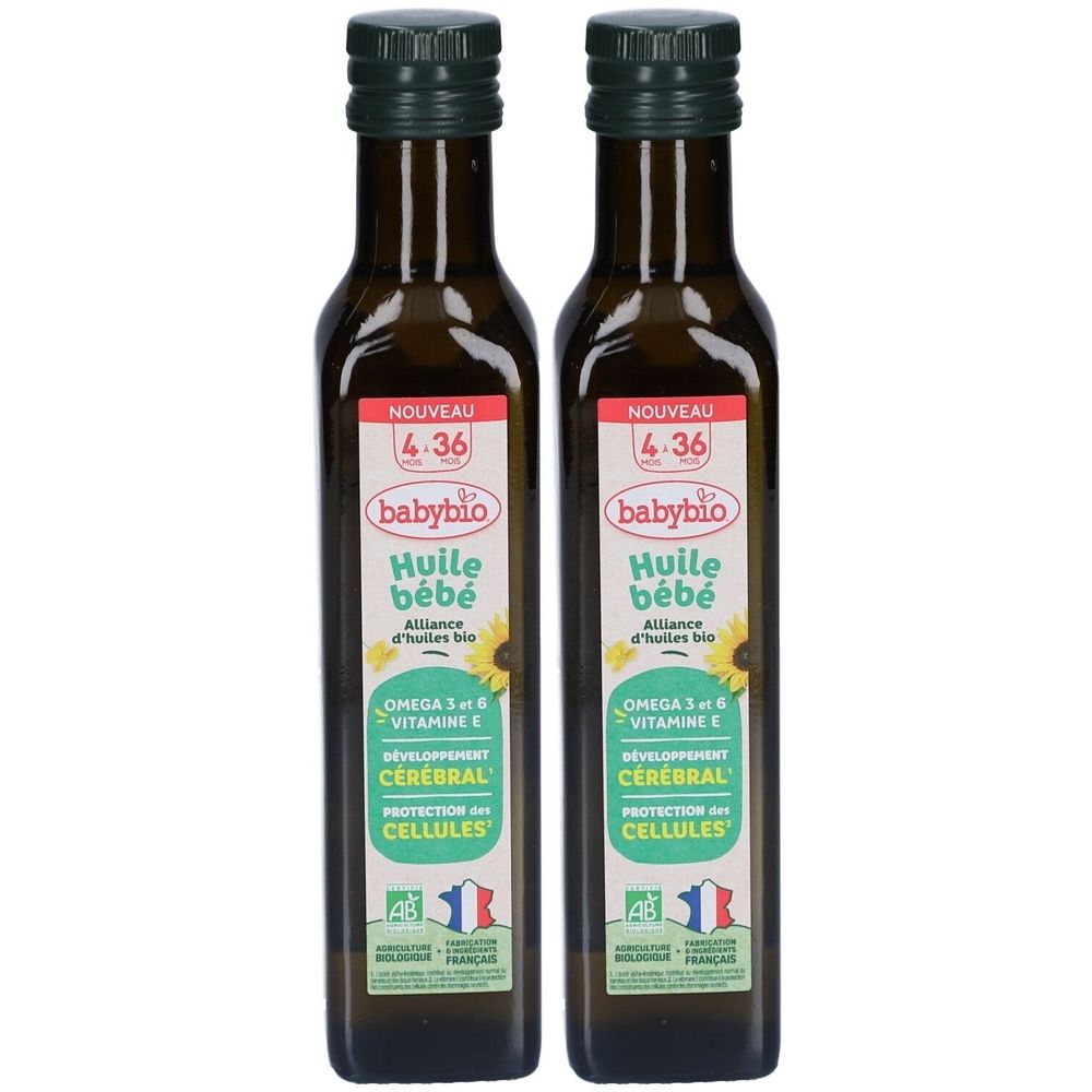 Deux flacons d'huile pour bébé. Étiquettes avec nom du produit, tournesol et logos. Bouchons verts et bouteilles en verre brun.