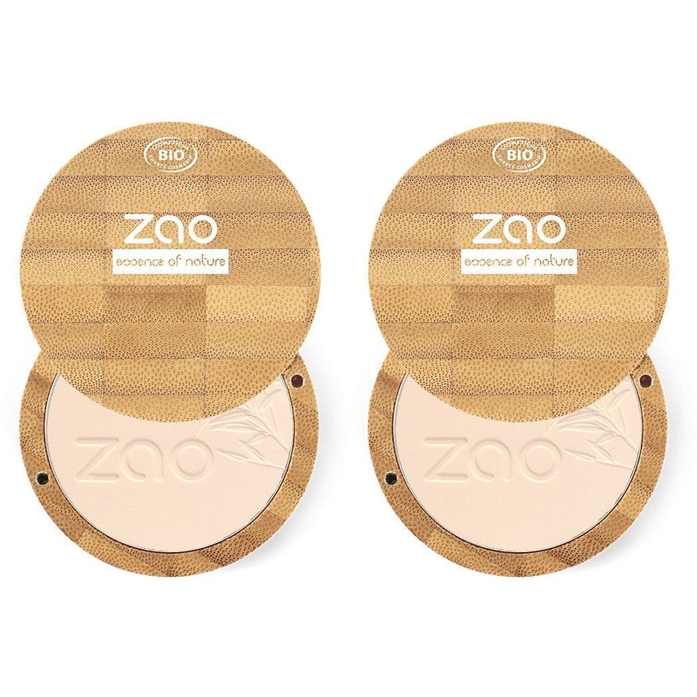 Deux poudres compactes rondes ouvertes. Couvercles en bois avec logo et certification bio. Poudre beige clair. Marque ZAO.