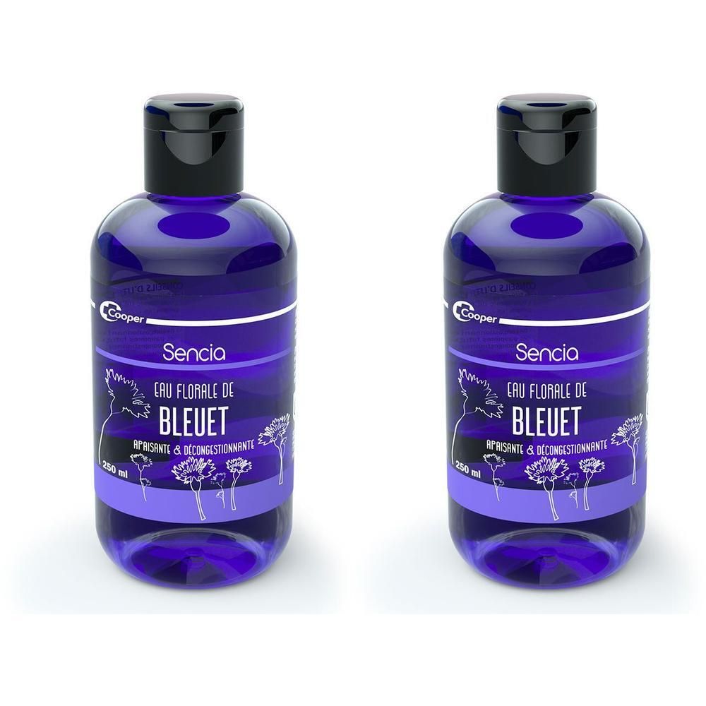 Deux flacons bleus avec bouchons noirs. Inscription Sencia Eau Florale de Bleuet. Étiquette avec motif floral.