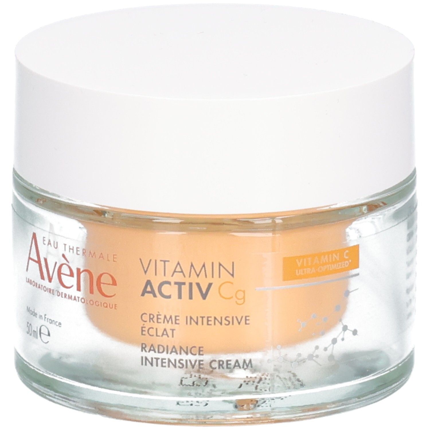 Pot en verre avec couvercle blanc. Inscription: Avene, Vitamin Activ Cg, Crème Intensive Eclat, Radiance Intensive Cream. Contenu orangé.