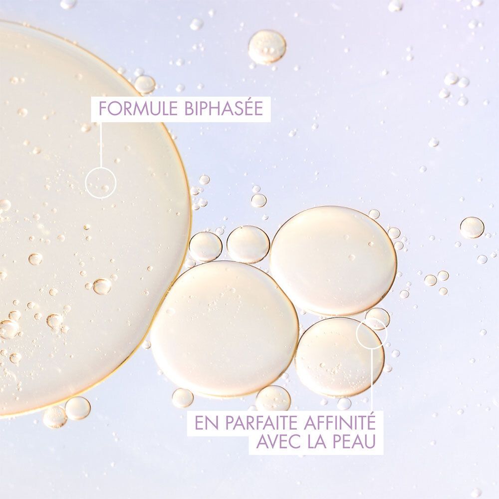 Gros plan sur des gouttes de liquide. Texte : Formule Biphasée, En parfaite affinité avec la peau.