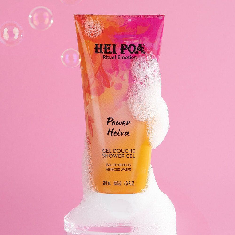 Tube Hei Poa Gel Douche Power Heiva avec mousse et bulles sur fond rose.