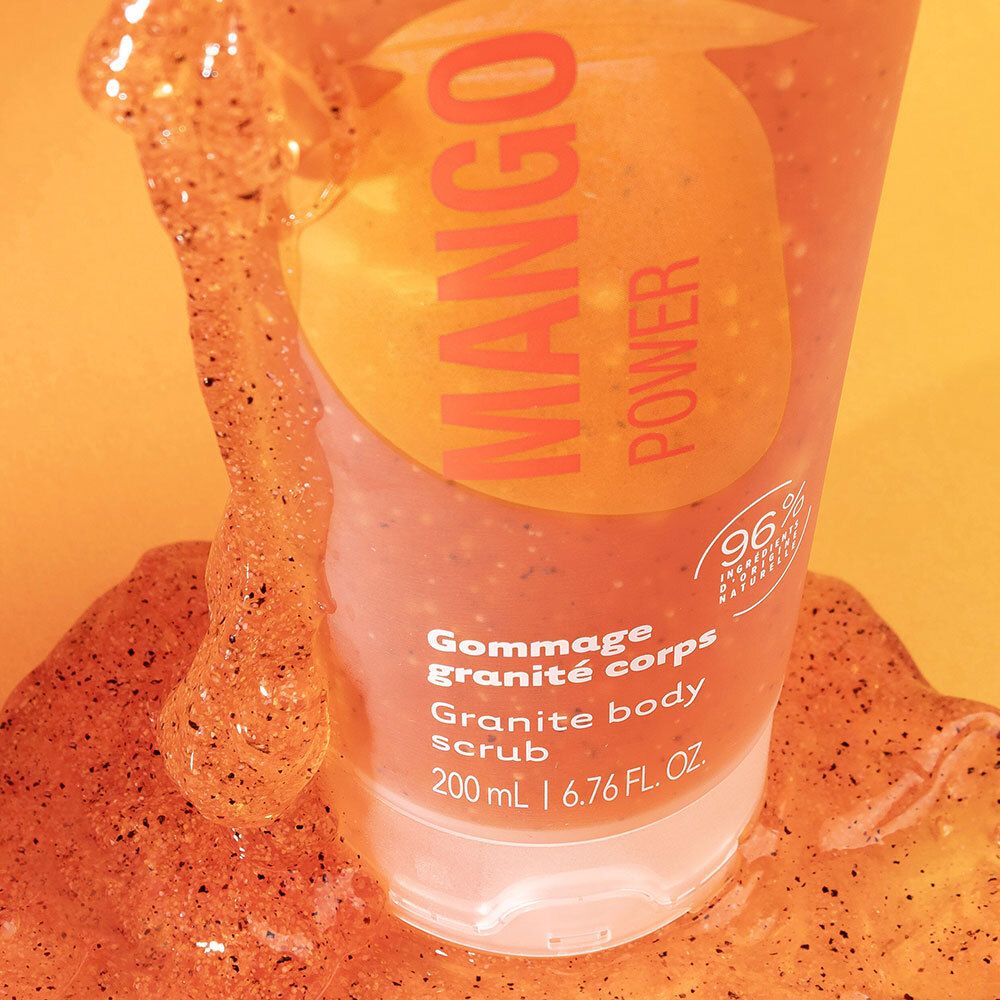 Gros plan du gommage corps granité Laino Mango Power avec des particules de gommage visibles.