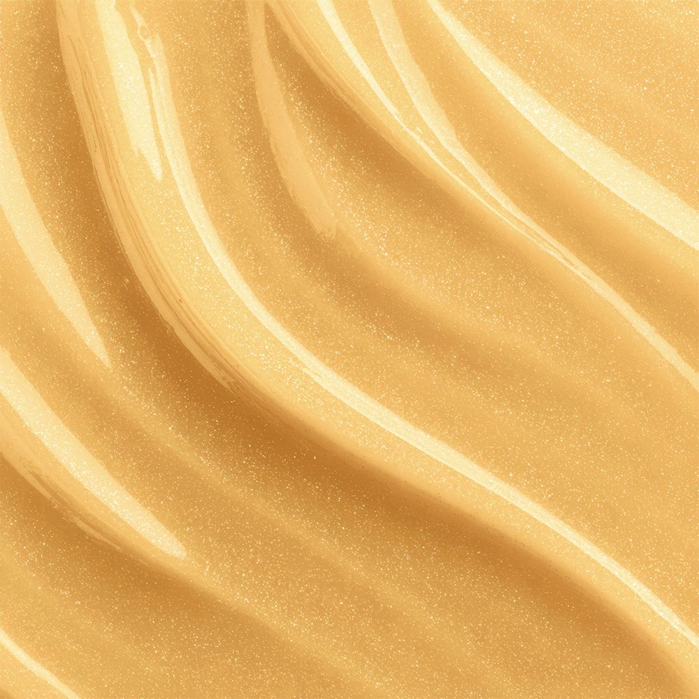 Gros plan de la texture d'un sérum jaune doré avec des particules brillantes.