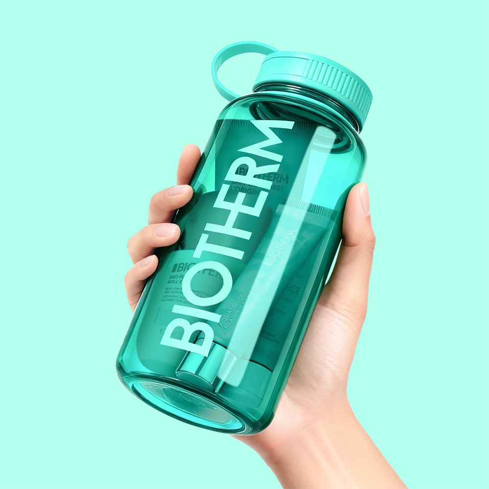 Bouteille d'eau Biotherm turquoise avec marques de mesure, tenue par une main.