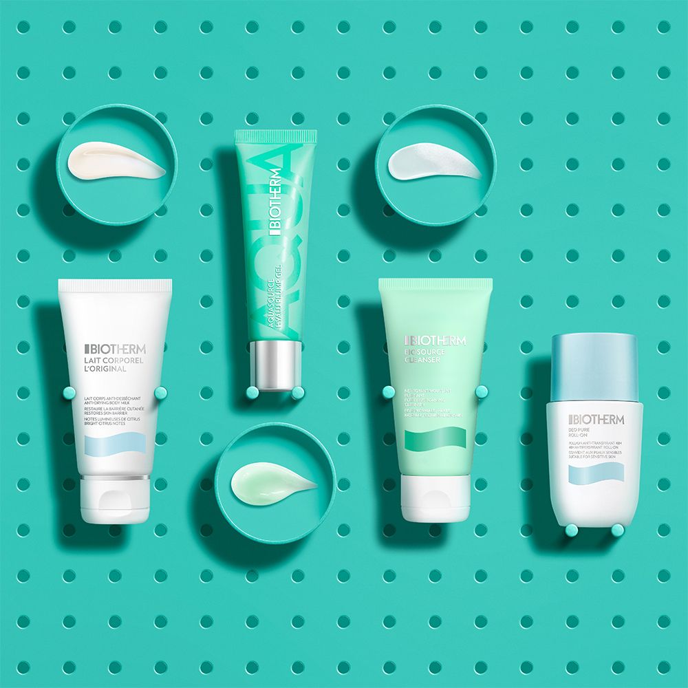 Cinq produits de soin Biotherm, y compris des tubes et des pots, sur fond turquoise.