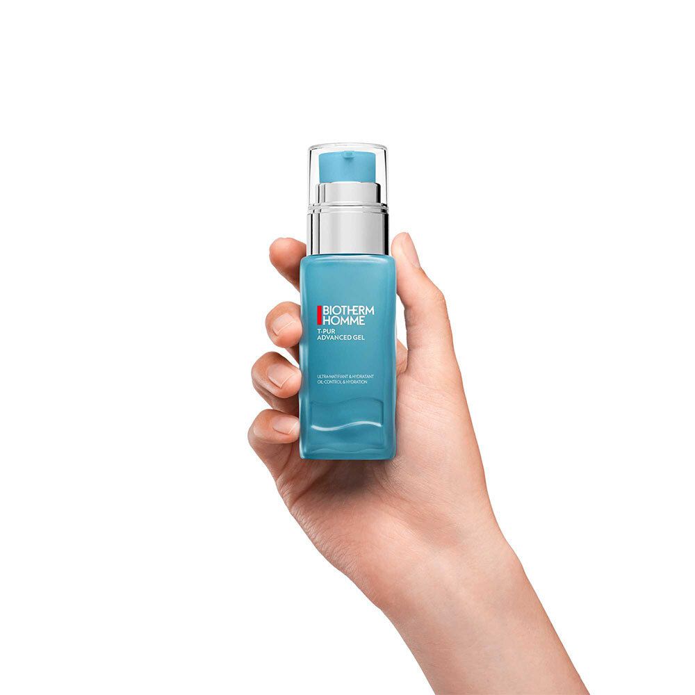 Main tenant le flacon de gel bleu. Tête de pompe argentée. BIOTHERM HOMME, T-PUR ADVANCED GEL.