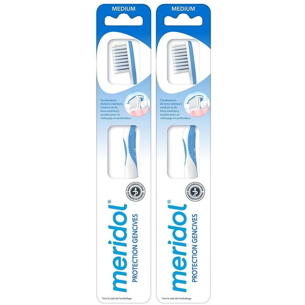 Deux brosses à dents emballées. Manches bleues, soies blanches. Inscription : Meridol Protection Gencives.