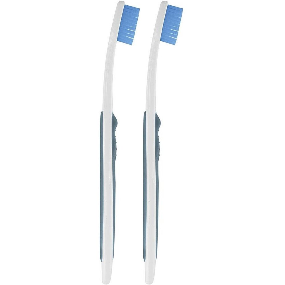 Deux brosses à dents avec manches blancs, soies bleues et accents gris. Les brosses sont côte à côte.